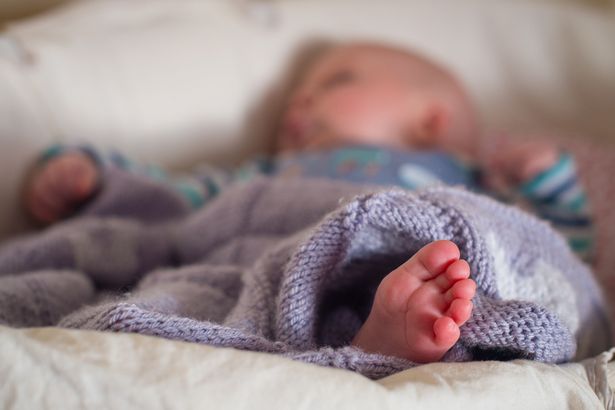 Un bébé dort dans un panier