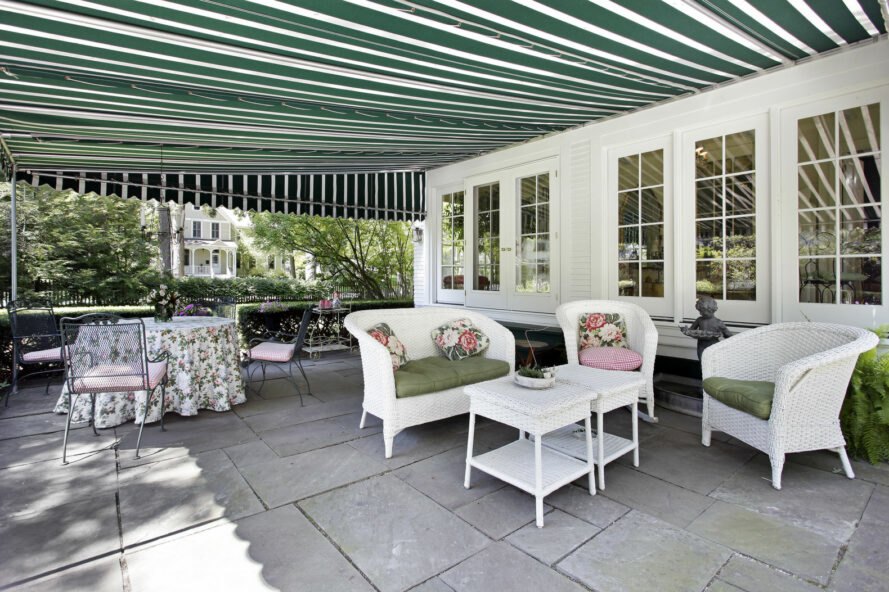 patio avec sièges sous un auvent à rayures vertes et blanches