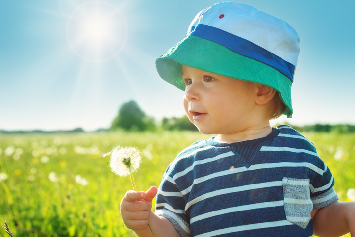 un bébé portant un chapeau dehors au soleil
