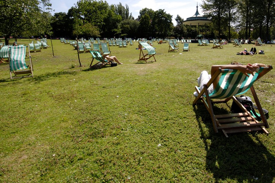 Personnes assises dans des chaises longues sur l'herbe dans un parc par une journée ensoleillée