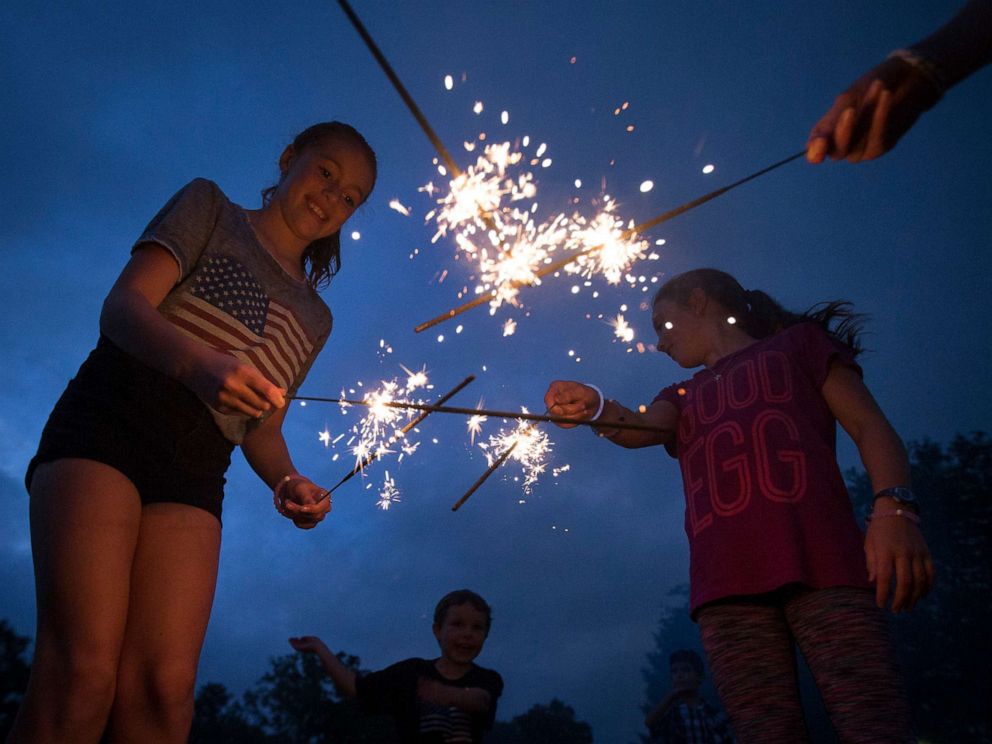 PHOTO: Dans cette photo d'archives, Lila Flynn-Tonbragel, à gauche, joue avec des feux de Bengale en attendant le début des feux d'artifice du 4 juillet à Ault Park, le 4 juillet 2016 à Cincinnati.