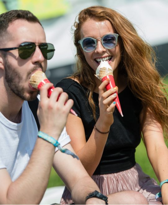 Les festivaliers dégustent des glaces sous la fin de l'après-midi ensoleillée - ambiance de festival le premier après-midi du festival Festival de Glastonbury