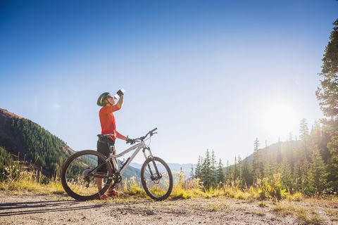 Homme caucasien, à, vélo montagne, eau potable, dans, montagnes