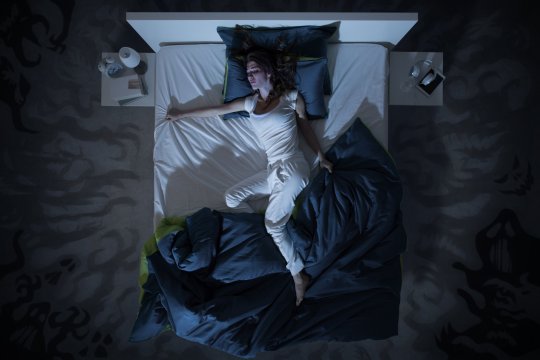 Femme nerveuse souffrant d'insomnie et couchée tard dans la nuit, elle est éveillée et agitée, vue de dessus