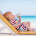 enfant en bas âge en buvant une bouteille d'eau sur la plage