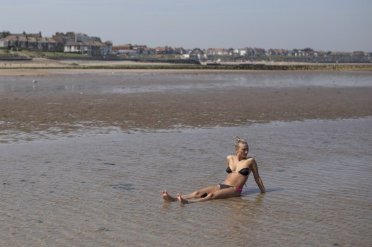 MARGATE, ROYAUME-UNI - 25 juillet: une femme est assise en eau peu profonde tout en bronzant le 25 juillet 2019 à Margate, Royaume-Uni. Le Met Office a émis un avertissement météo à partir de 15 heures cet après-midi. Ils préviennent que la Grande-Bretagne pourrait faire face à jusqu'à 13 heures de tempêtes électriques après que les températures pourraient atteindre un 39C record. (Photo de Dan Kitwood / Getty Images)